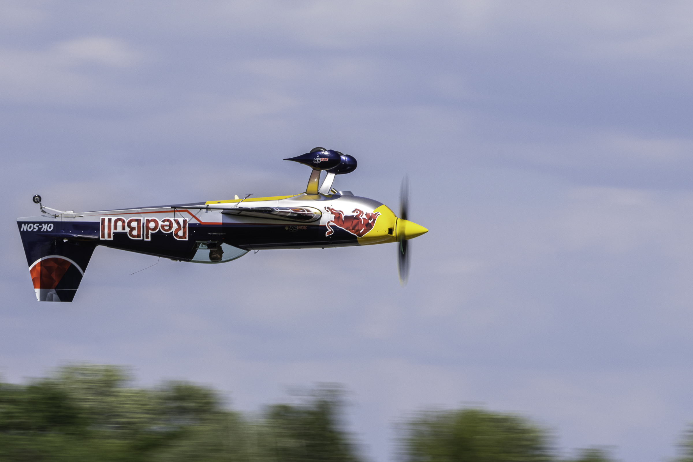 Red Bull Extra 300SR flying inverted low over the treetops