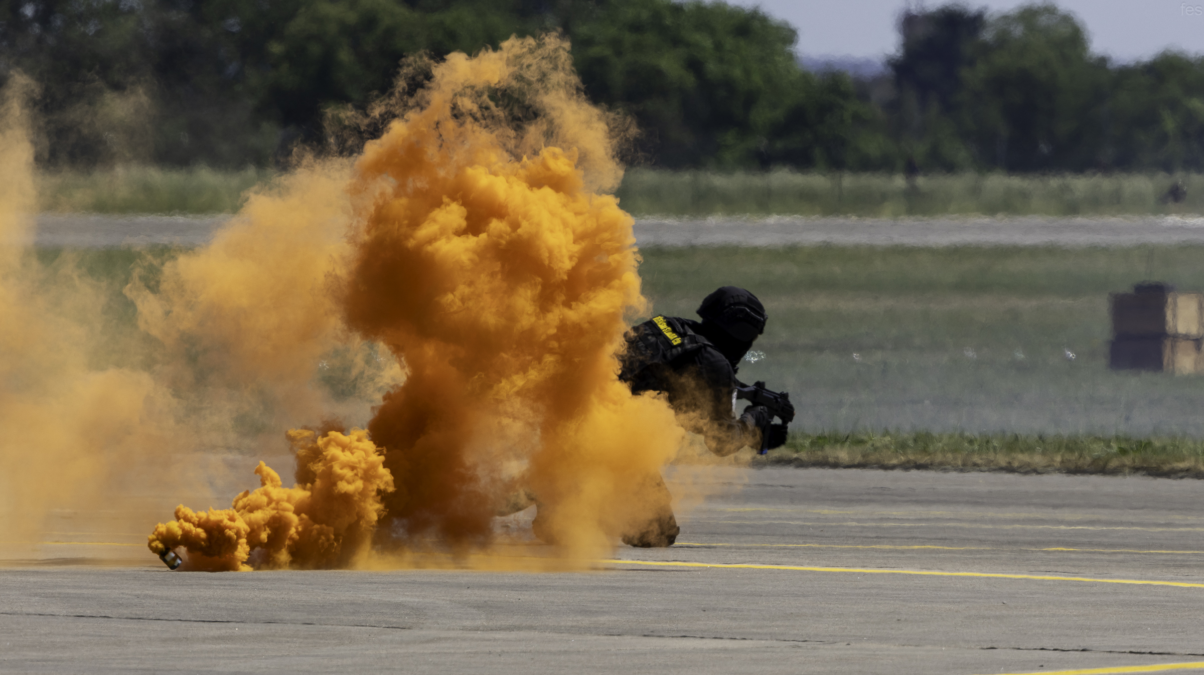 Soldier emerging from a cloud of orange signal smoke during the special-forces demonstration